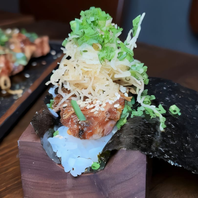 Asian-fusion dish with grilled meat, shredded vegetables, and sesame seeds in a wooden holder.